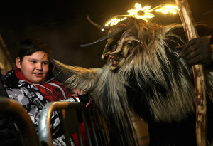 Krampus - in search of delinquent children, approaches a little boy during Krampusnacht in Neustift im Stubaital, Austria, on November 30, 2013.